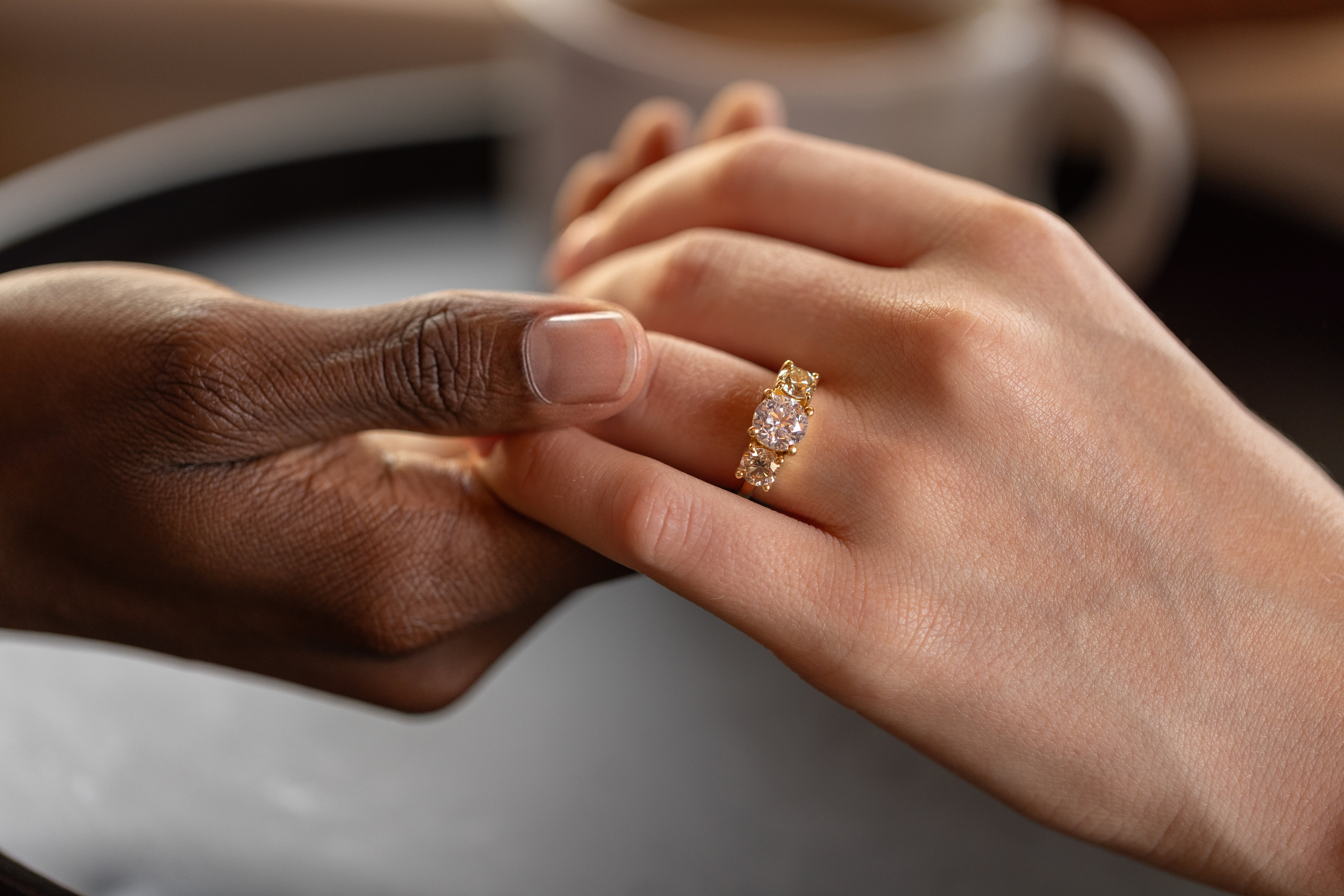 Pair of hands held with an engagement ring on one 